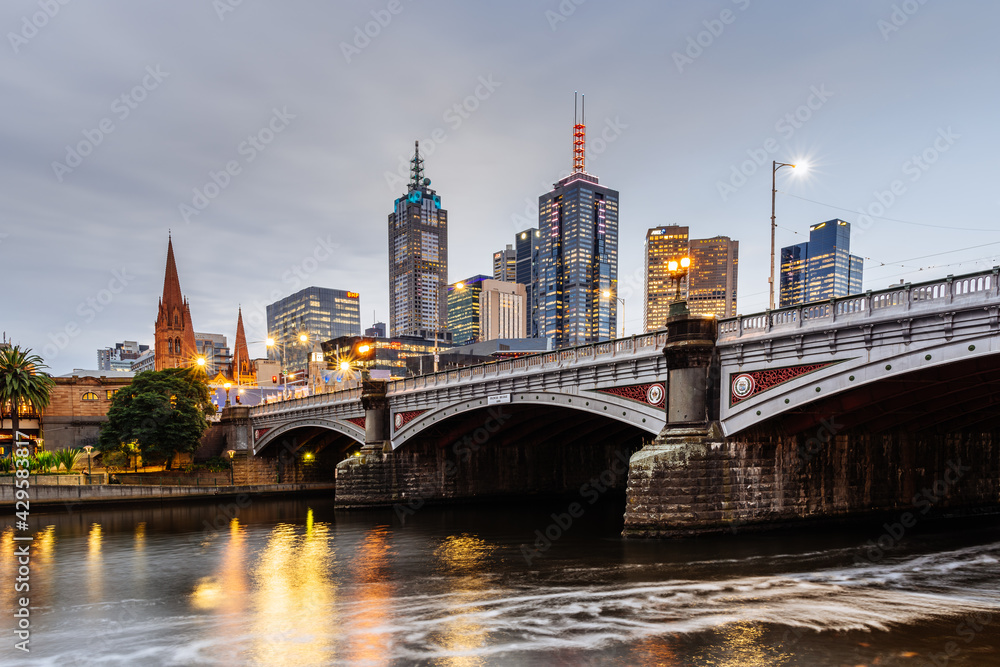 Naklejka premium Princes Bridge and city buildings on the Yarra River in Melbourne, Australia in the evening - 2021