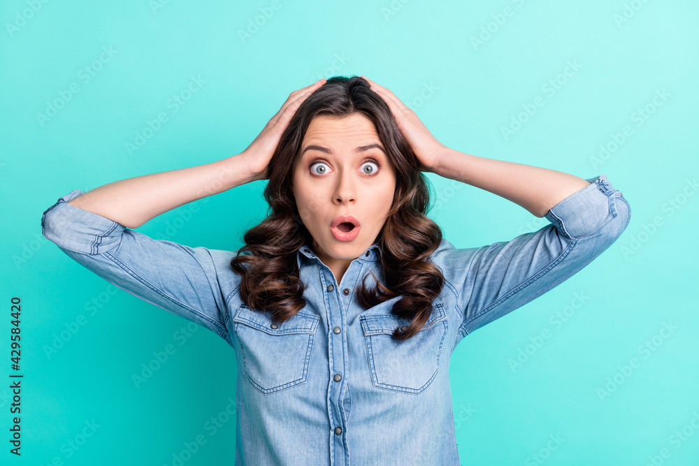 Photo of young attractive girl hands touch head amazed shocked fake novelty news isolated over turquoise color background