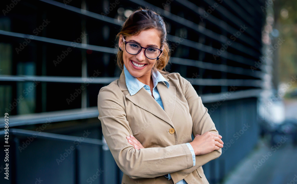 Young smiling business woman standing in front of the office Young smiling business woman standing in front of the office