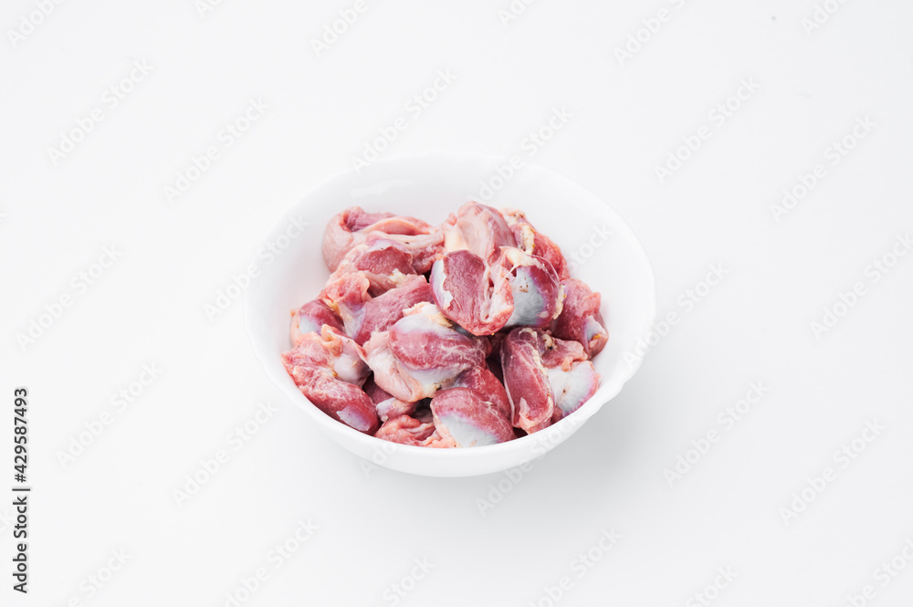 Raw chicken thighs on a white plate on a white background. Mockup
