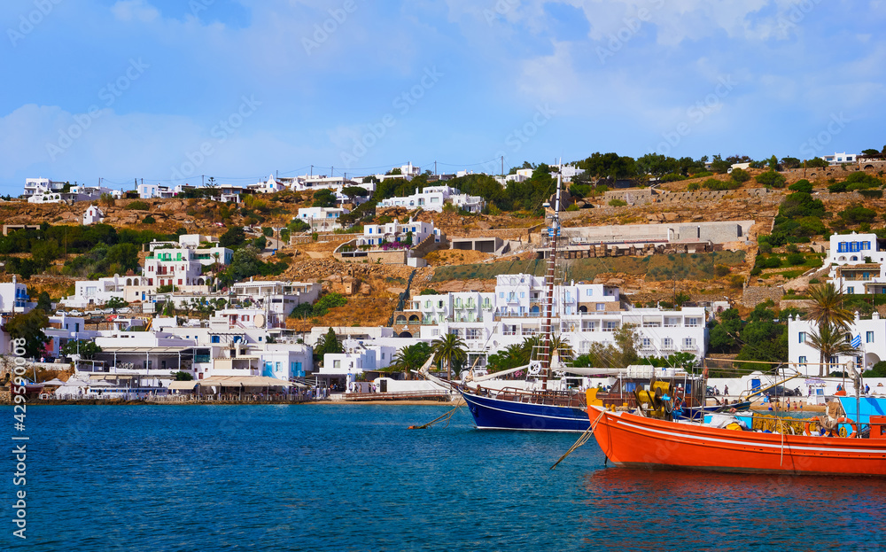 Beautiful summer day on Greek island, Mykonos, Greece. Fishing boats at jetty. Whitewashed houses, mediterranean lifestyle, vacations, summer. 