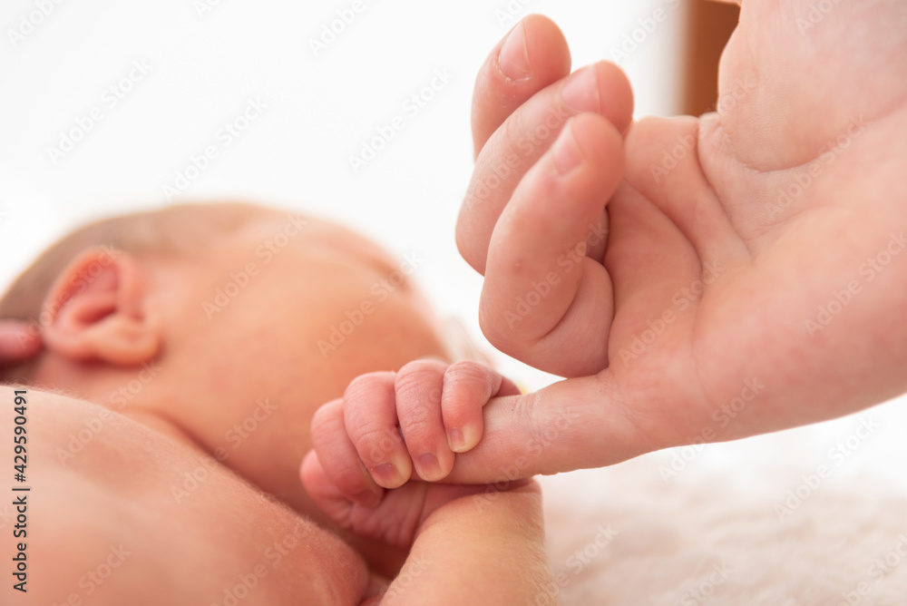 Italy, April 2021. The hand of a very small child holds the hand of the mother Italy, April 2021. The hand of a very small child holds the hand of the mother