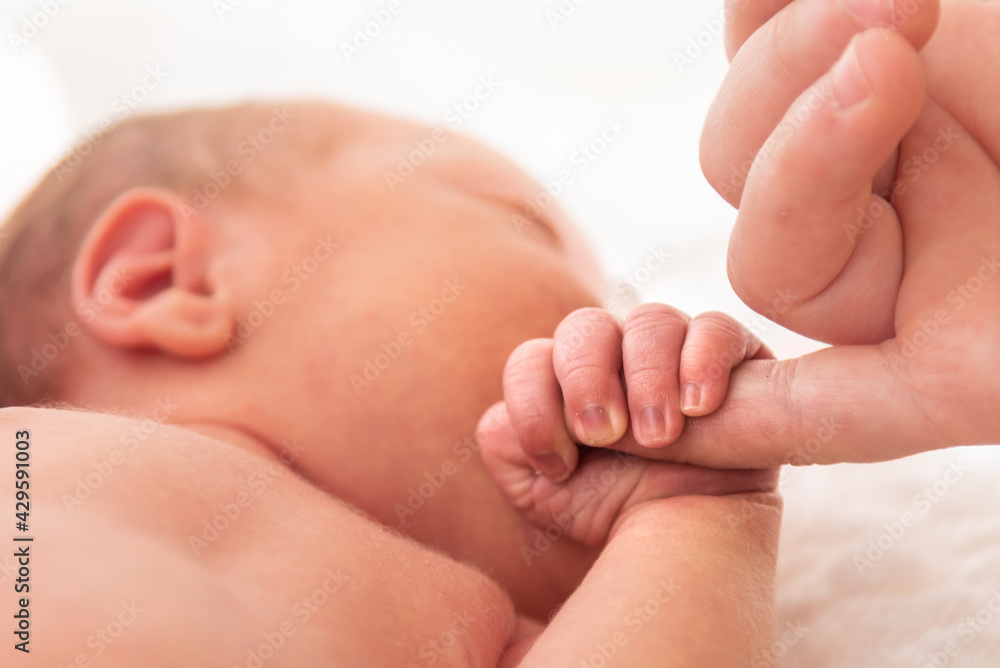 Italy, April 2021. The hand of a very small child holds the hand of the mother Italy, April 2021. The hand of a very small child holds the hand of the mother