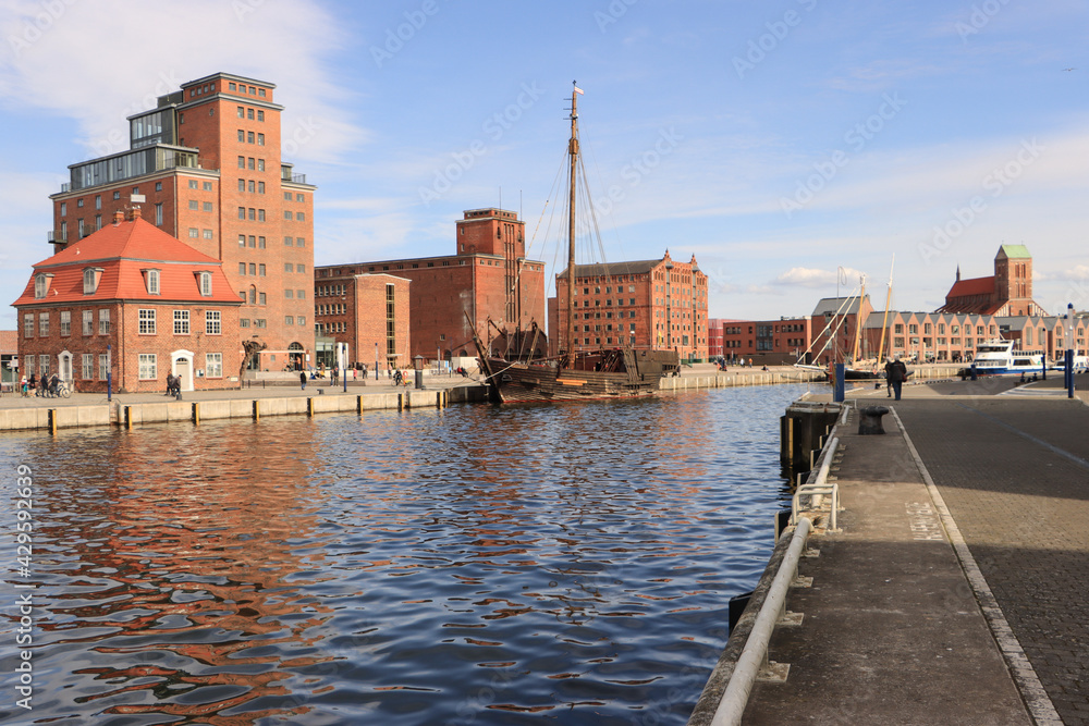 Obraz premium Hansestadt Wismar; Alter Hafen mit Baumhaus, Speichern und Nikolaikirche