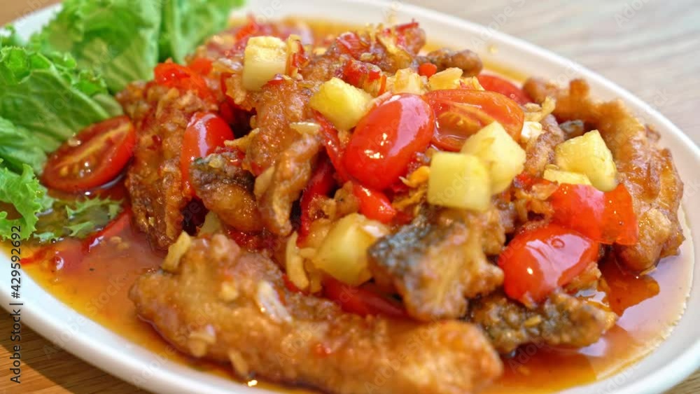 fried grouper fish topped with sweet ,sour and hot sauce on white plate - Asian food style fried grouper fish topped with sweet ,sour and hot sauce on white plate - Asian food style