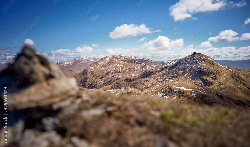 The mountain summits of Meall nan Tarmachan, Meall Garbh and Ben Lawers in the distance from the summit of Beinn nan Eachan in the spring. Scottish Highlands, UK Landscapes. The mountain summits of Meall nan Tarmachan, Meall Garbh and Ben Lawers in the distance from the summit of Beinn nan Eachan in the spring. Scottish Highlands, UK Landscapes.