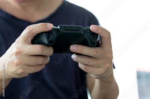 Young man holding game controller playing video games, Selected focus fingers