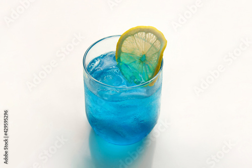 Blue Hawaii cocktail with lemon sliced on white background