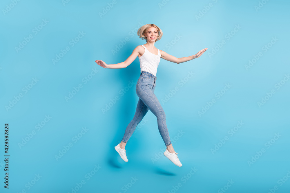 Full body profile side photo of happy young cheerful lady jump up go empty space isolated on blue color background