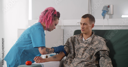 Young man soldier giving blood in hemotransfusion center photo
