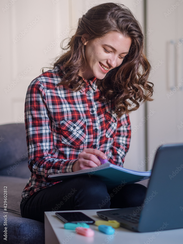 one young woman, smiling and happy, reading or writing in book. one young woman, smiling and happy, reading or writing in book.