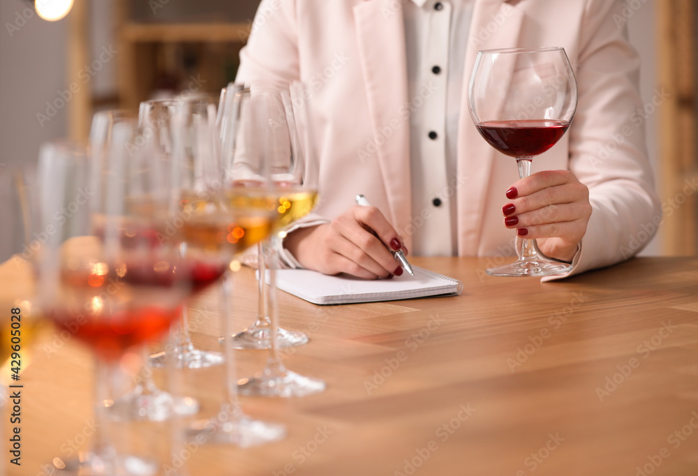 Sommelier tasting different sorts of wine at table indoors, closeup Sommelier tasting different sorts of wine at table indoors, closeup