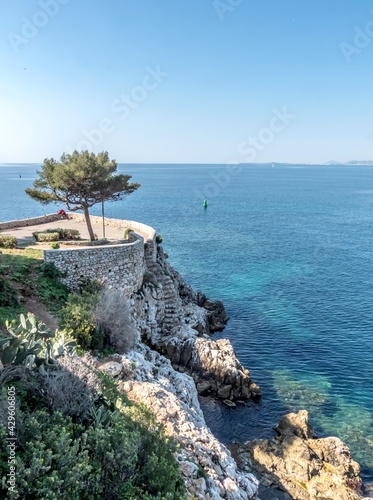 Chemin de rochers en bord de mer à Nice avec un kiosque et un pin maritime