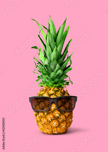 Fresh pineapple fruit with sunglasses on pink copyspace background