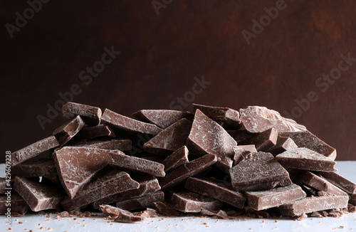 Pezzi di cioccolato isolati su sfondo marrone. Copia spazio.