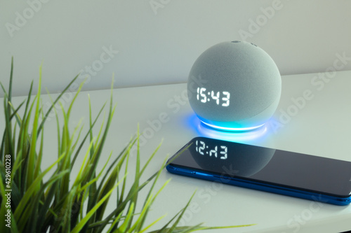 Voice controlled speaker with activated voice recognition, on light background.