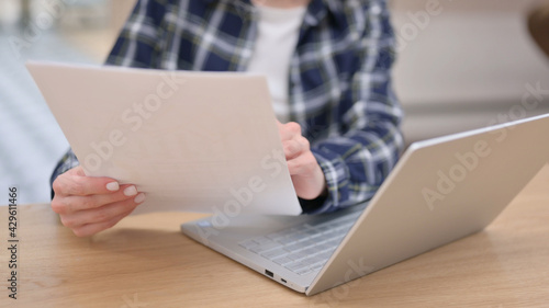 Female Reading Documents while using Laptop, Close up