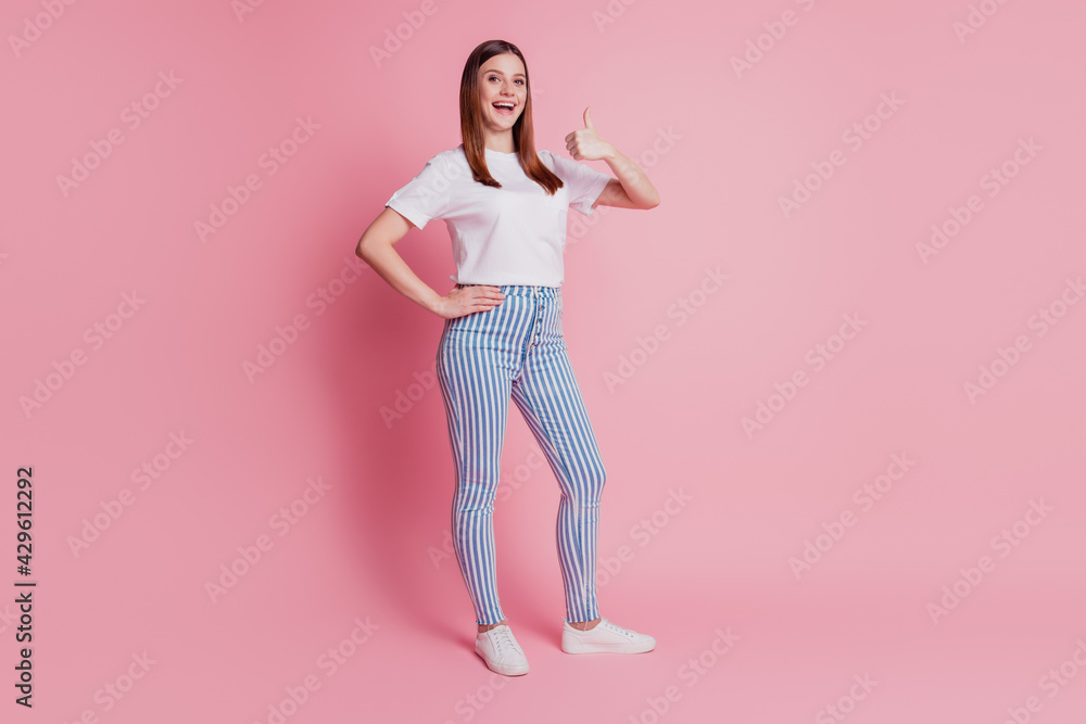Charming promoter lady showing thumb up on pink background Charming promoter lady showing thumb up on pink background