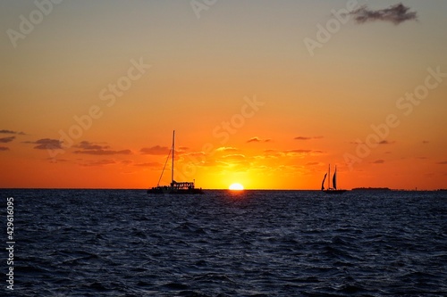 Sunset and sailboat silhouettes on the horizon viewed from Mallory Square, Key West, USA © Aaron Weiler