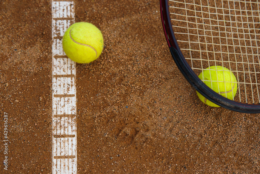 Tennis balls and racket on court