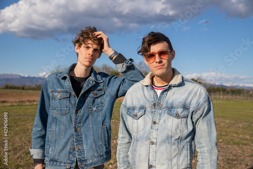 Canvas Print Two brothers dressed in denim jackets pose in a field in the open air, brotherho