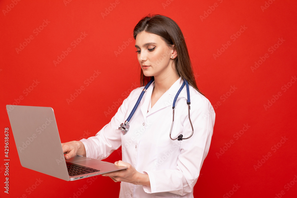 Portrait of a young female doctor in a white coat with a laptop Portrait of a young female doctor in a white coat with a laptop