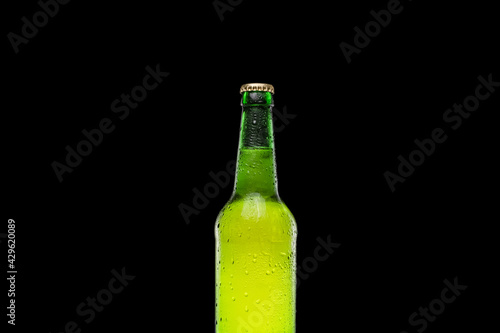 Fresh and cold green beer bottle on black background