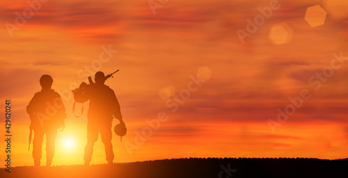 Military man and military woman on sunset background is symbol of equal rights. © arsenypopel