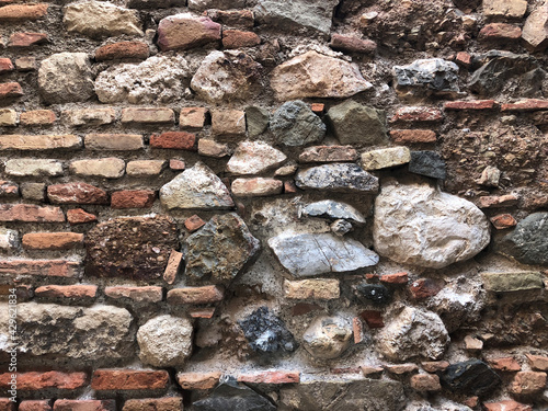 Old ancient wall with different stones as abstract background