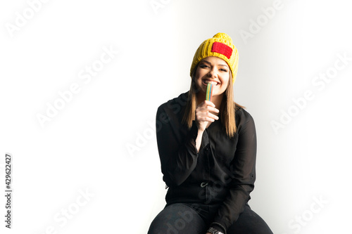 A young girl in a yellow hat who likes sweet candy photo