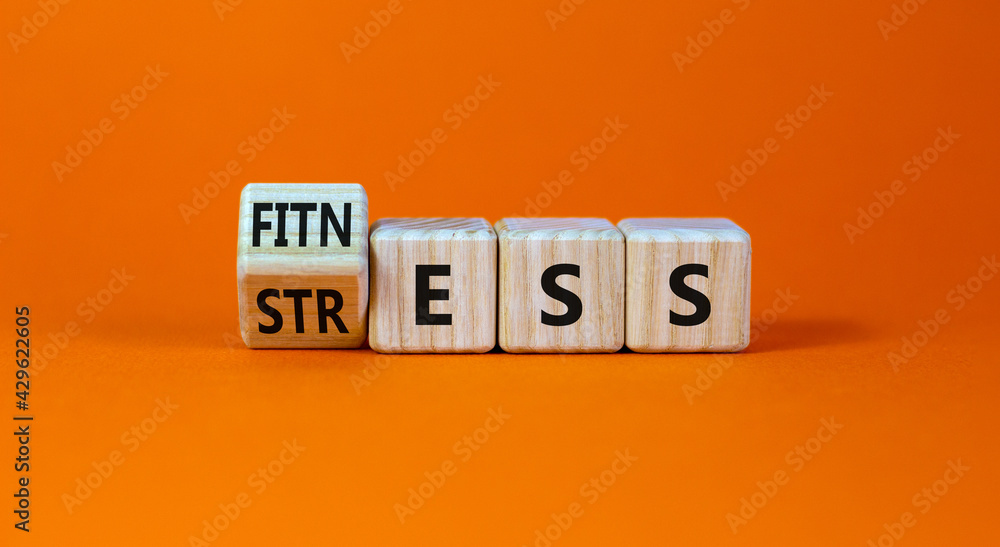 Fitness vs stress symbol. Turned the cube and changed the word 'stress' to 'fitness'. Beautiful orange background. Medical, psychological, fitness vs stress concept. Copy space. Fitness vs stress symbol. Turned the cube and changed the word 'stress' to 'fitness'. Beautiful orange background. Medical, psychological, fitness vs stress concept. Copy space.