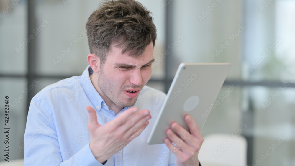 Young Man Reacting to Loss on Tablet