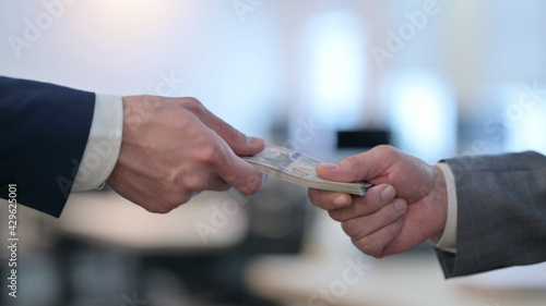 Close up of Hand of Businessmen Giving Dollar to another Person 