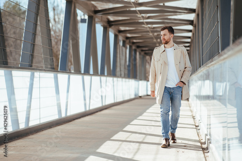 Man walks down the street in beige coat