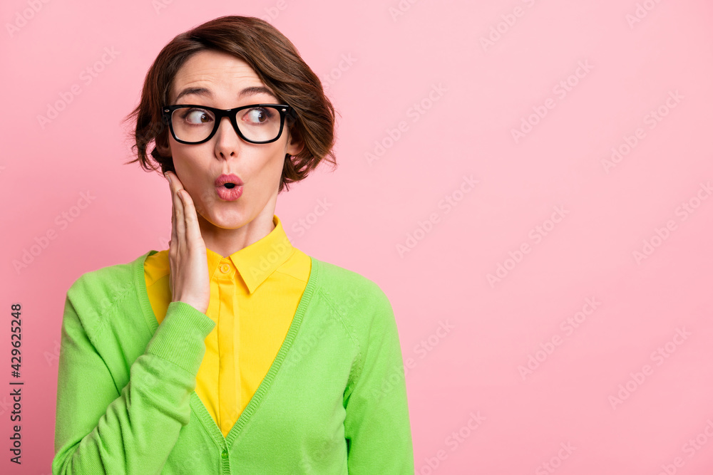 Photo of impressed cute young lady dressed yellow shirt glasses looking empty space arm cheek isolated pink color background