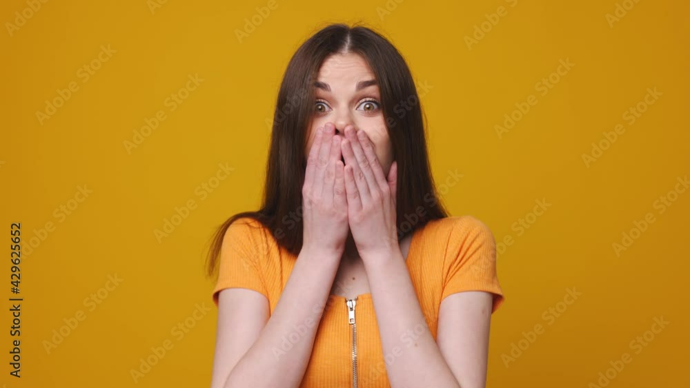 Woman emotion of surprise and happiness, jumping with delight on a yellow background Woman emotion of surprise and happiness, jumping with delight on a yellow background
