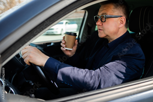 Elderly man experience self-driving smart car and has a cup of coffee © F8  \ Suport Ukraine