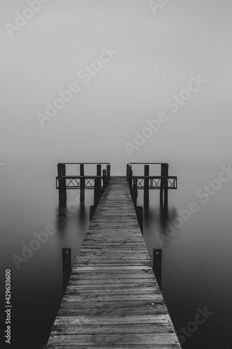 Pier leading into a lake in a foggy afternoon in Te Anau, New Zealand