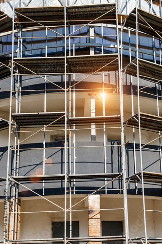 Extensive scaffolding providing platforms for work in progress on a new apartment block,Tall building under construction with scaffolds,Construction Site of New Building