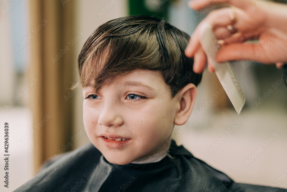 Haircut for little kid boy, professional barber doing haircut. Hairdress for children Haircut for little kid boy, professional barber doing haircut. Hairdress for children