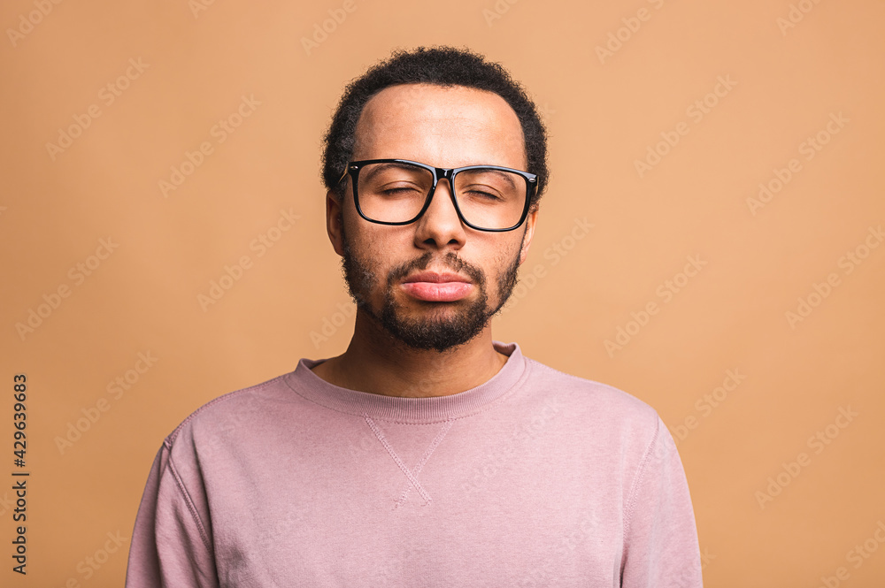 Head shot studio portrait over beige blank isolated afro american sad man feels frustrated and unhappy having broken heart personal problems, desperate guy misunderstanding concept.