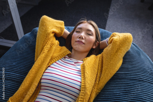 Obraz na plátně Mixed race businesswoman chilling in office relaxing space lying in beanbag