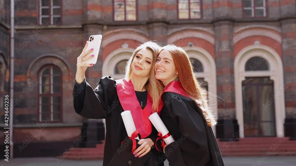 Pretty woman graduate taking selfie with diploma, red ribbon scroll using smartphone, young women posing Pretty woman graduate taking selfie with diploma, red ribbon scroll using smartphone, young women posing
