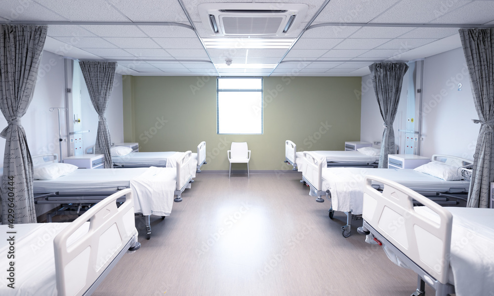 General view of an empty hospital room with two rows of beds