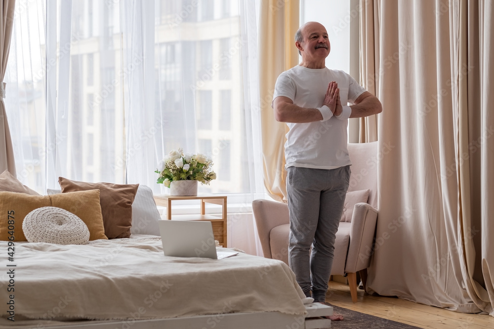 Portrait of a healthy senior man standing in tadasana doing sun salutation. Portrait of a healthy senior man standing in tadasana doing sun salutation.