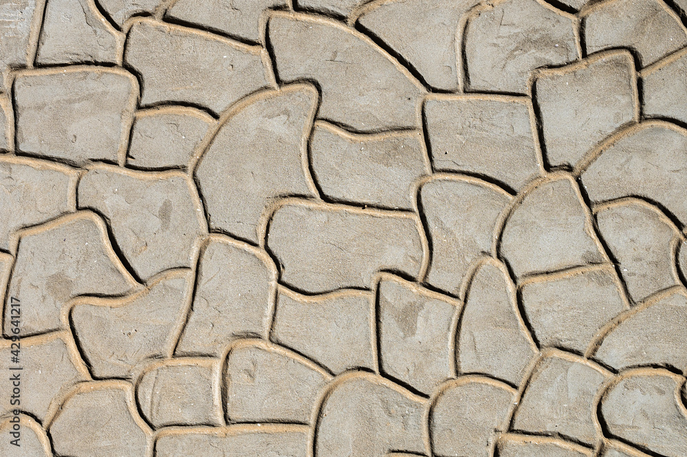 A wall of cement on which a stone pattern is extruded. Imitation stone coating