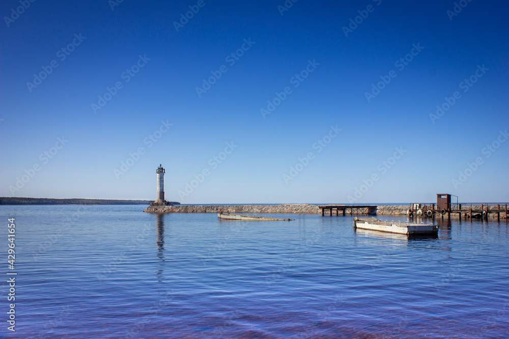 A lighthouse in sunny weather. Lighthouse on the breakwater. Lighthouse on the lake. A lighthouse in sunny weather. Lighthouse on the breakwater. Lighthouse on the lake.