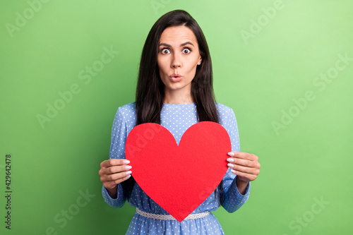 Photo of impressed brown hair lady hold paper heart wear blue dress isolated on green color background