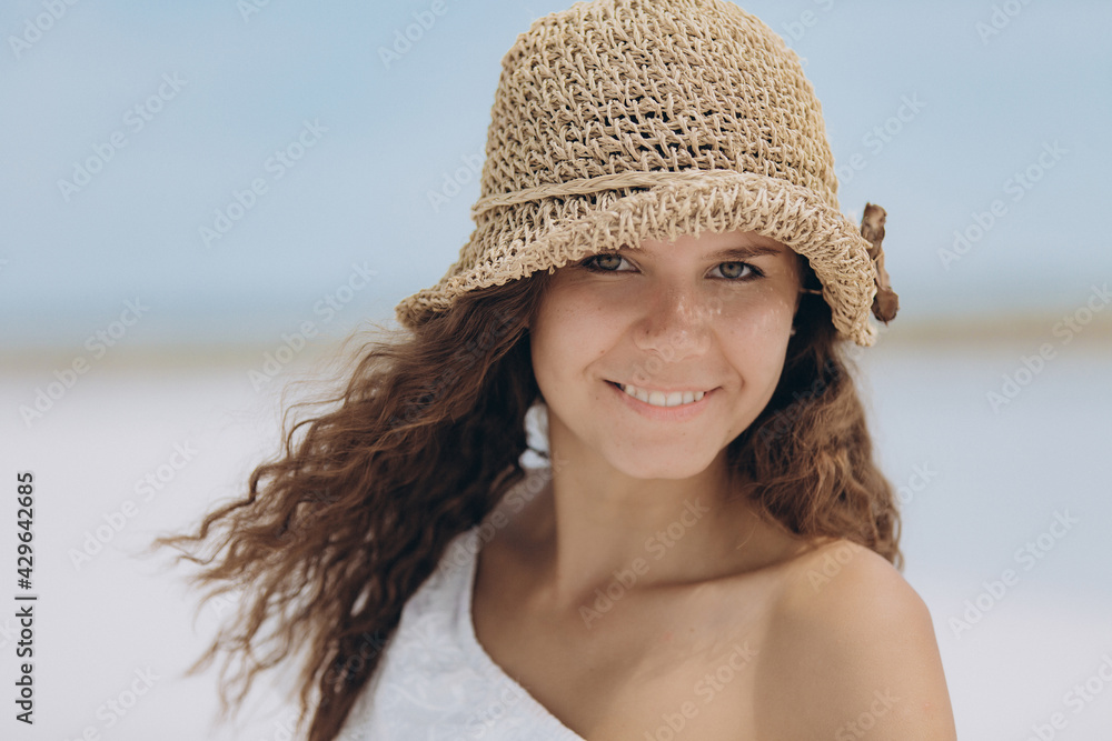 Portrait of a beautiful girl in a straw hat. Look into the camera and smile.