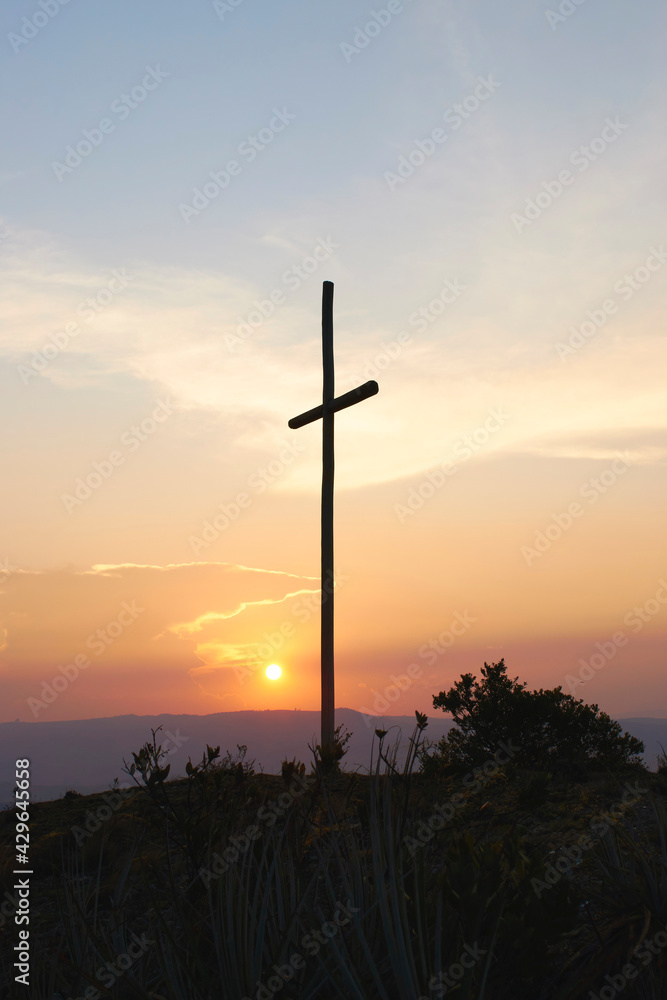 Wooden cross during sunset in a field Wooden cross during sunset in a field